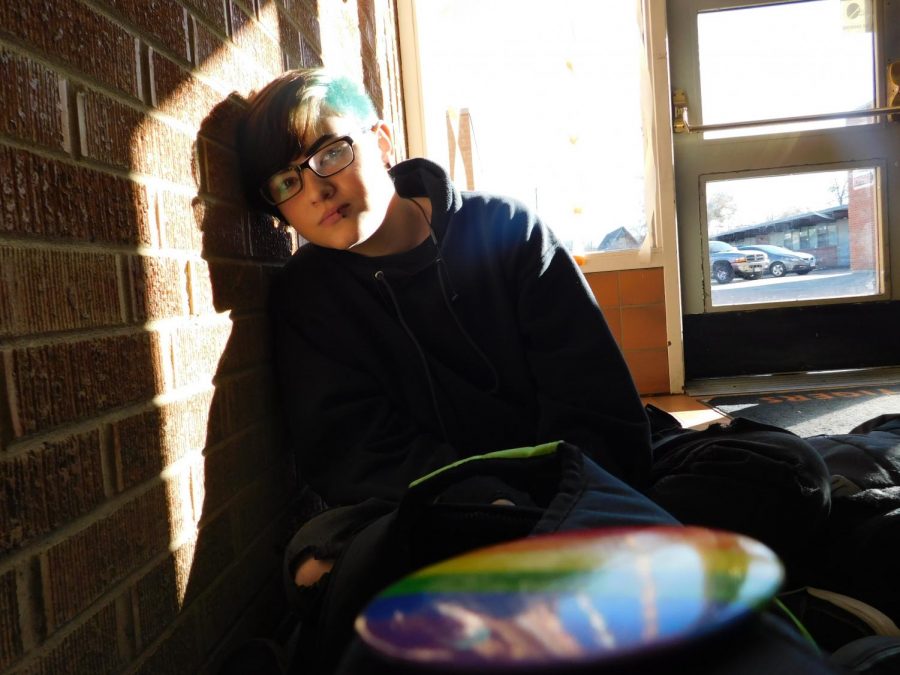 Sophomore sits in the sun light in commons.