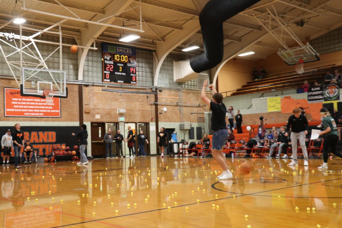 GHS sophomore Andrew Henderson attempts a half-court shot during the halftime Chuck a Duck, a fund-raiser during the event.