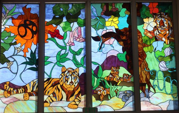 As of recently, this glass mural has been taken out of the school and been replaced with regular clear glass. This stained glass mural will be placed into the new school as well.