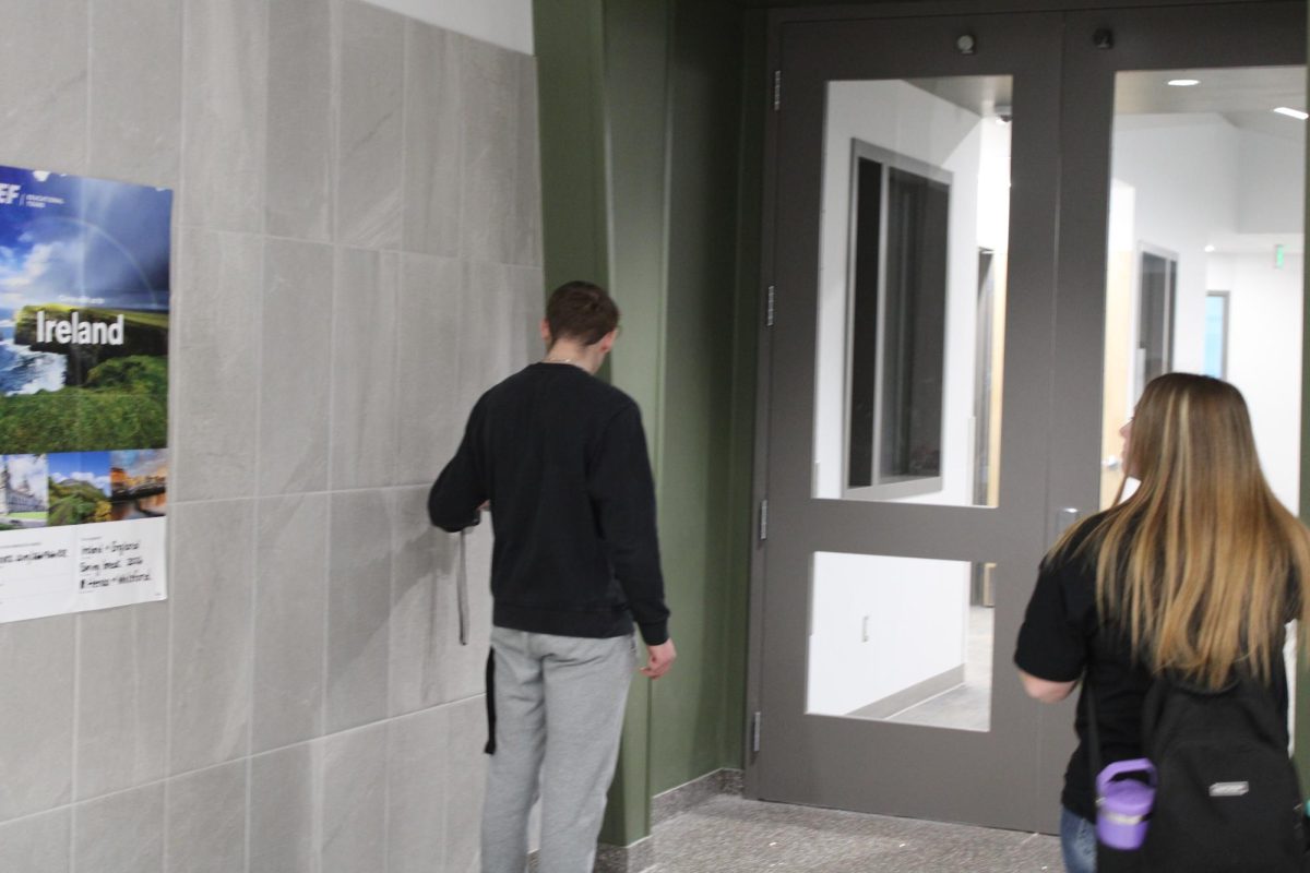 GJHS office aide Junior Brennan Young letting students in the 2nd floor  academic wing.